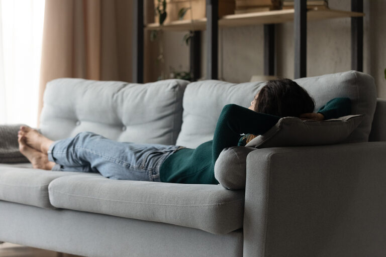 Calm Young Woman Lying On Couch At Home Sleeping Calm young woman lying on couch at home sleeping